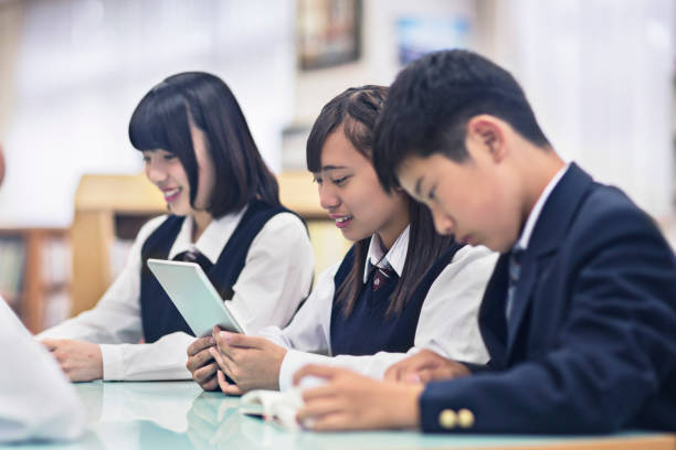 japonês os alunos na biblioteca da escola leitura - japanese culture asian ethnicity friendship computer imagens e fotografias de stock