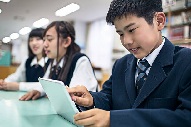 japonês estudantes usando um tablet digital na biblioteca da escola - japanese culture asian ethnicity friendship computer imagens e fotografias de stock