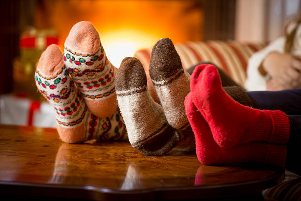 Closeup of family feet in wool socks at fireplace Closeup photo of family feet in wool socks at fireplace heat home interior comfortable human foot stock pictures, royalty-free photos & images