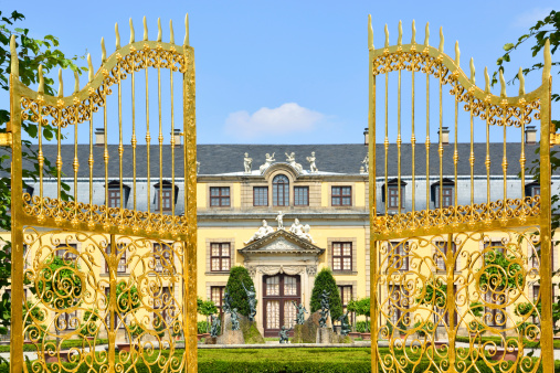 Hannover, Germany - July 25, 2013: Golden gate in front of the Gallery Building in the Great Garden. The Great Garden of Herrenhausen Gardens, is unique garden grounds, laid out in a baroque style, are one of the most famous attractions in Hannover. They were sculpted in 1699 on the request of princess Sophie. The gardens are a heritage of the Kings of Hannover and they have always been one of the most distinguished baroque formal gardens of Europe. The gardens are considered popular recreation areas for the residents of Hannover.The history of the gardens spans several centuries, and they remain a popular attraction to this day.