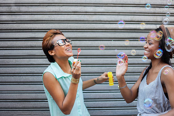 istock Two African girls blowing bubbles 493565783