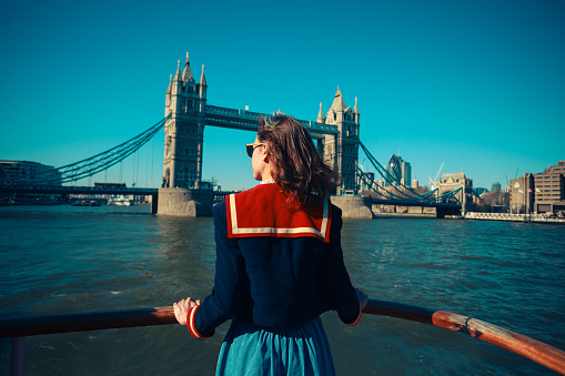 Mujer joven en una embarcación vista a Tower Bridge en Londres photo