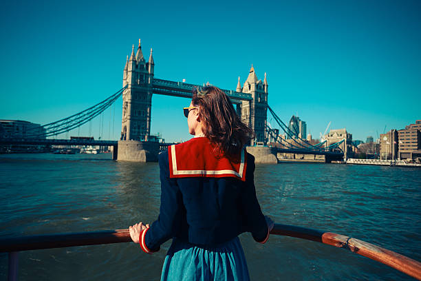 giovane donna in barca alla ricerca sul tower bridge a londra - tower bridge london england thames river international landmark foto e immagini stock