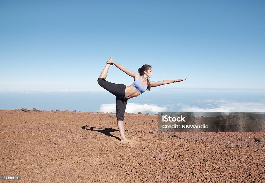 Young woman doing yoga in the nature Woman doing the dancer pose in the nature, over the clouds Adult Stock Photo