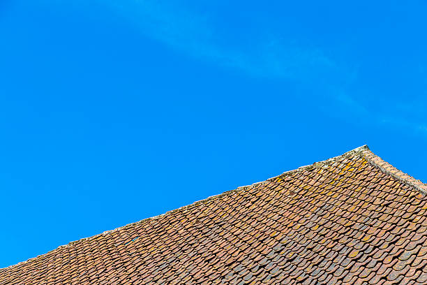 istock roof tile over blue sky 493569141