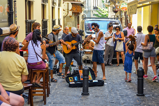 Granada, Spain - August 13, 2015: Street musicians performing on side alley in Granada, Spain with tourists and locals spectating. Photo taken during the day.