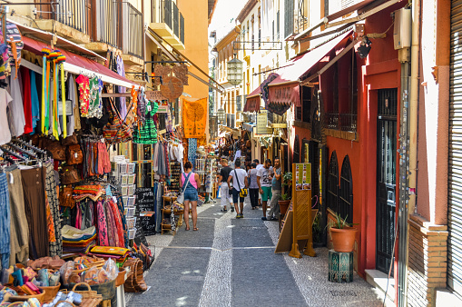 Granada, Spain - August 13, 2015: Arabic street market in Granada, Spain located in the Albaycin. Picture features local shops and tourists browsing their wares.