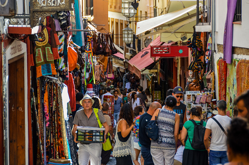 Granada, Spain - August 13, 2015: Arabic street market in Granada, Spain located in the Albaycin. Picture features local shops and tourists browsing their wares.