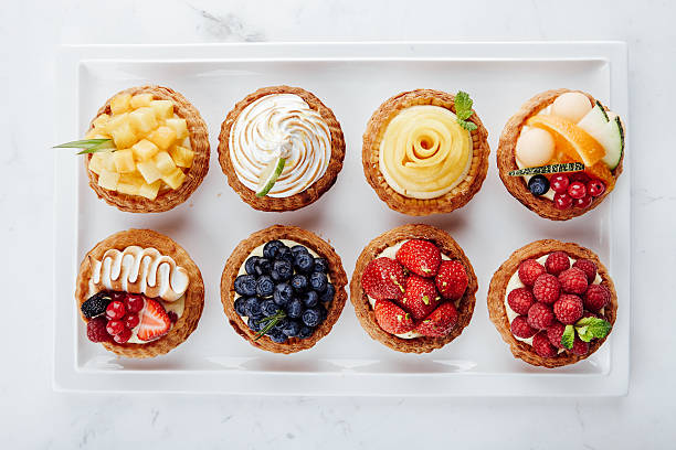 Close up of fruit tarts and various desserts Delicious tart made with fresh strawberry, blueberry, mango and kiwi. tart dessert stock pictures, royalty-free photos & images