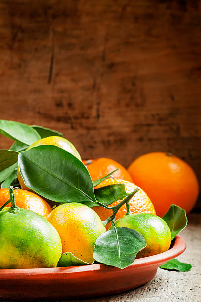 istock Orange and green ripe tangerines with leaves 493580334