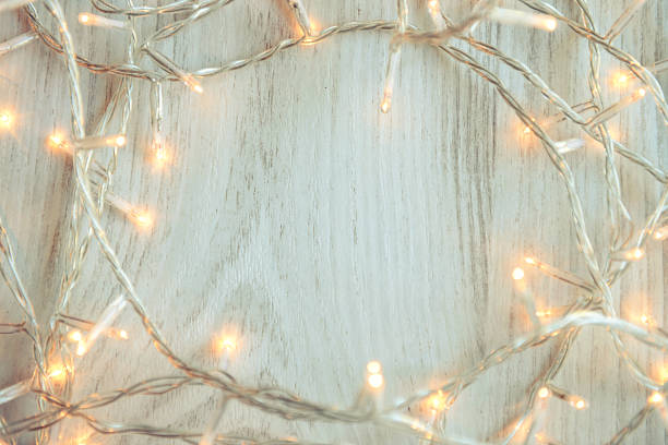 istock Christmas lights on white wooden background 493581120