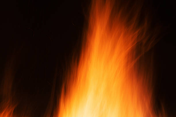 Flames and dark sky of a large night-time bonfire.