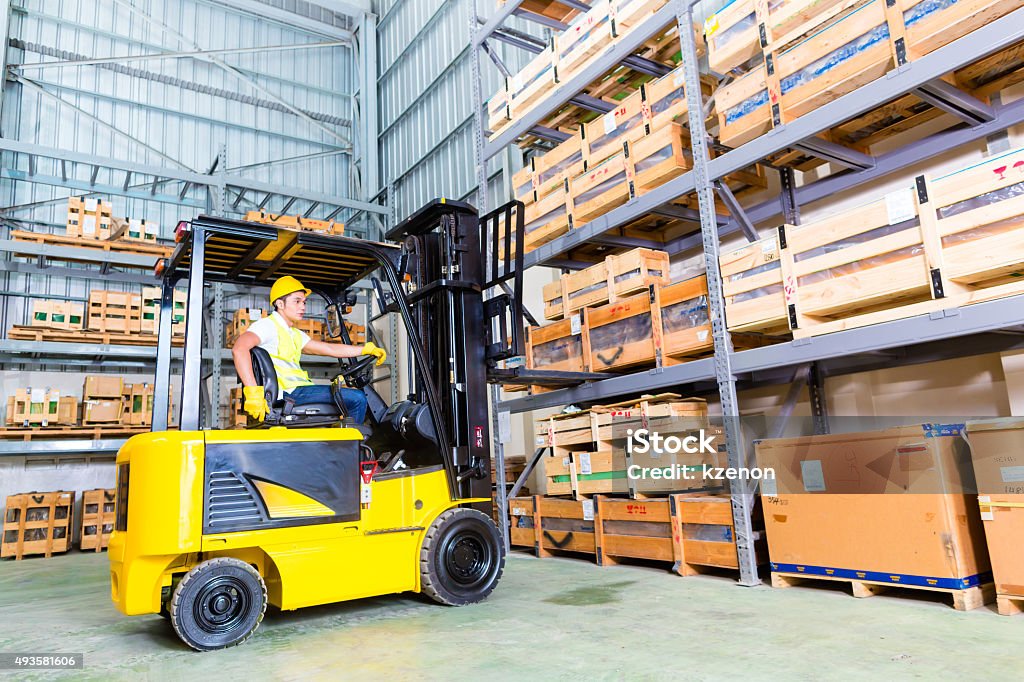 Asiatische fork lift truck driver lifting Paletten in Aufbewahrung - Lizenzfrei Gabelstapler Stock-Foto