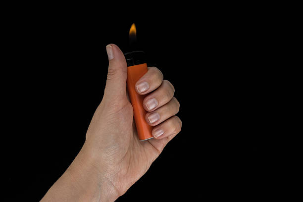 istock Burning lighter in female hand, isolated on black 493581668