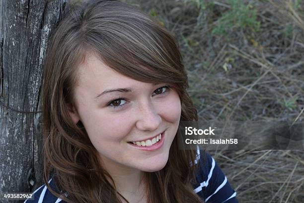 Young Lady Leaning Against A Rustic Fencepost Stock Photo - Download Image Now - 2015, Adult, Beautiful People