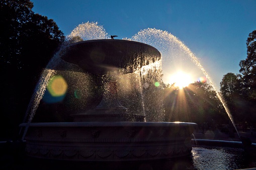 A water fountain in Park Saski (Warsaw, Poland) backlit by sun rays.