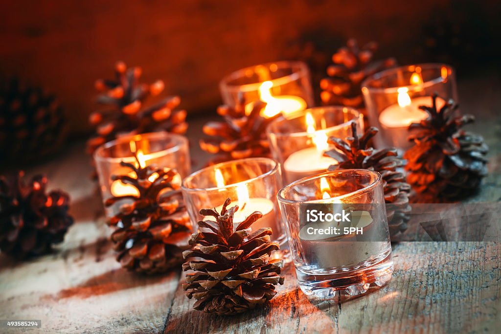 Christmas Christmas card with glowing small candle and fir cones Christmas Christmas card with glowing small candle and fir cones on old wooden background, dark toned image in country style, selective focus 2015 Stock Photo