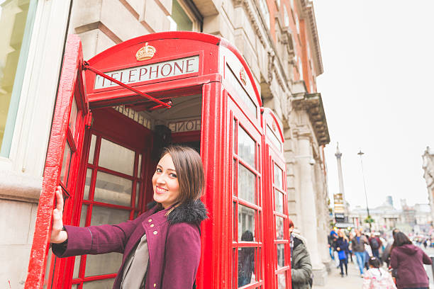istock Woman in London with a typical red phone booth 493587974