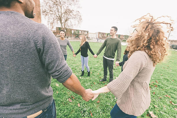 istock Multiethnic group of friends holding hands in a circle 493595734