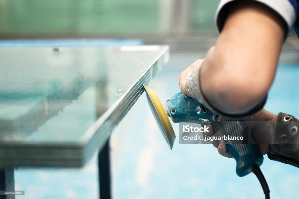 Polishing glass Operator with glass polishing machine. Glass - Material Stock Photo