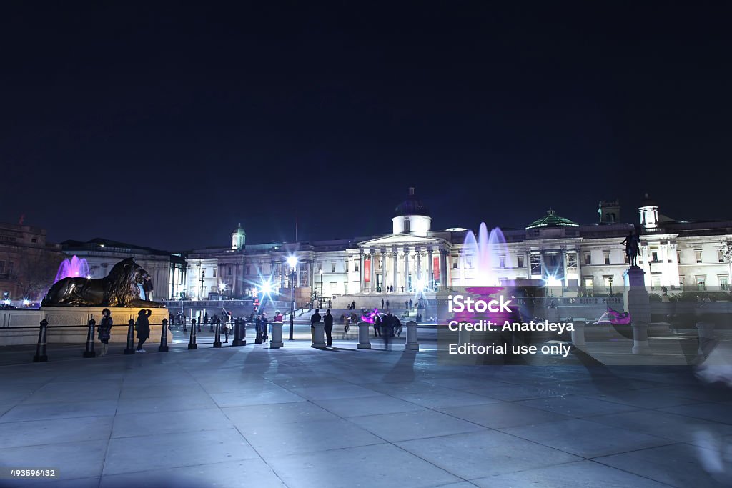 Trafalgar Square at night London, United Kingdom - November 25, 2011: Long exposure of tourists in Trafalgar Square at night by the fountains with the National Gallery in the distance.  2015 Stock Photo