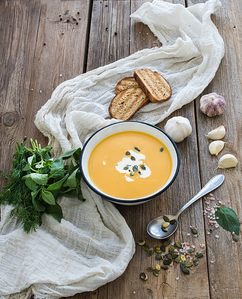 istock Pumpkin soup with cream, seeds, bread and fresh basil in 493602024