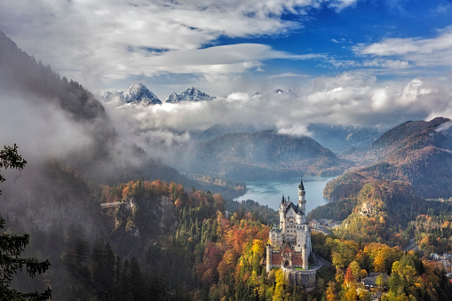 Fussen, Germany - October 17, 2015: Beautiful view of world-famous Neuschwanstein Castle, the nineteenth-century Romanesque Revival palace built for King Ludwig II on a rugged cliff, with scenic mountain landscape near Fussen, southwest Bavaria, Germany.