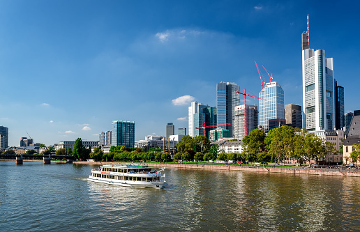 Frankfurt am Main, Germany- September 24, 2013: Boat cruise through the Main river and skyscrapers of Frankfurt am Main downtown. Frankfurt am Main is a dynamic and international financial and trade city with the most imposing skyline in Germany