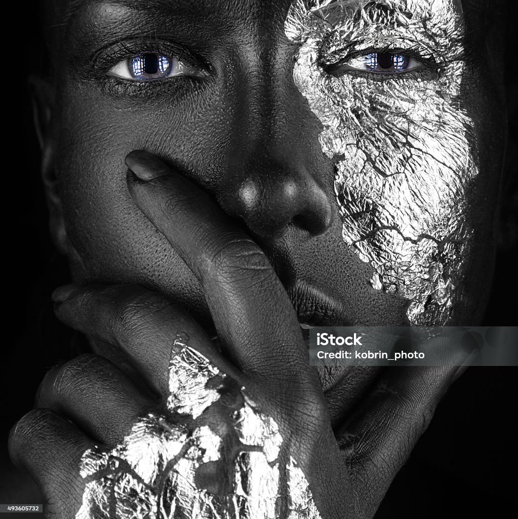 fashion portrait of dark-skinned girl with silver foil make-up. fashion portrait of a dark-skinned girl with silver foil make-up.Beauty face. Picture taken in the studio on a black background. Africa Stock Photo