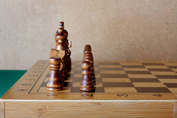 istock Wooden chess board with figures on table and old wall 493615553