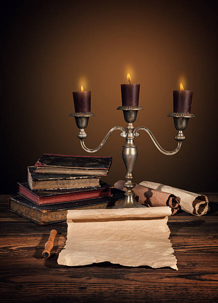 istock Old vintage books with candles in candlestick 493622190