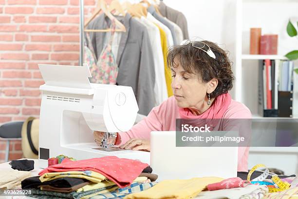 Seamstress Sitting At A Sewing Machine Stock Photo - Download Image Now - 2015, Accuracy, Adult