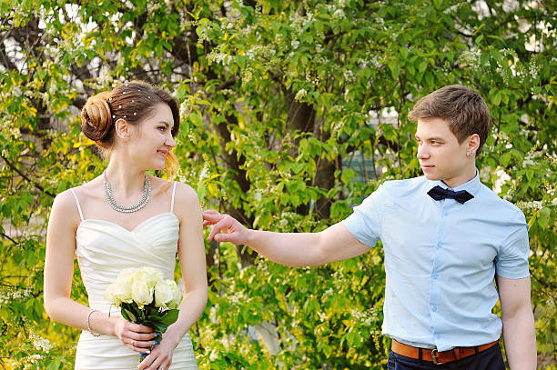istock bride and groom walking in the blossoming spring garden 493625602