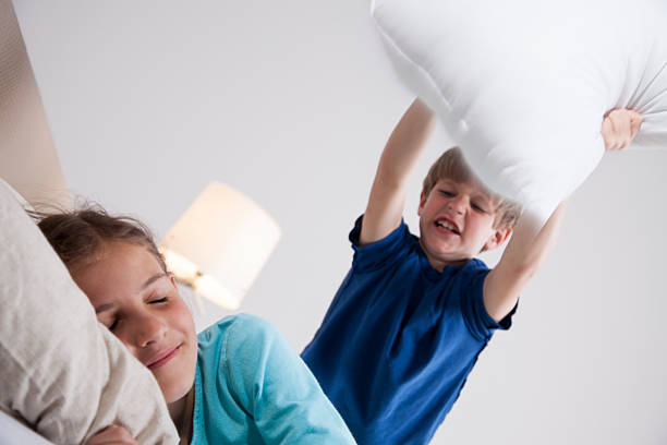 istock Young boy about to wake his sister with pillow 493625890