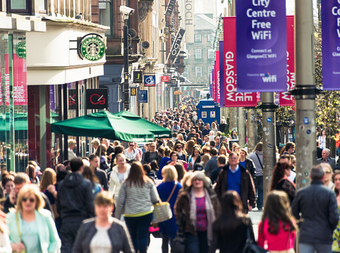 Crowds of people passing shops and businesses on Buchanan Street, one of Glasgow's busiest shopping streets.