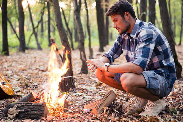 istock Man sitting near bonfire in the forest 493632858