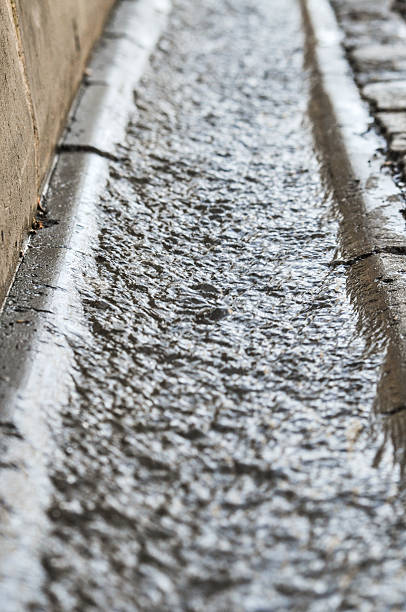 istock Flowing rain water near the road 493632981