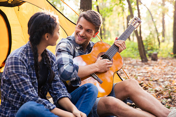 istock Couple sitting with guitar in the forest 493633500