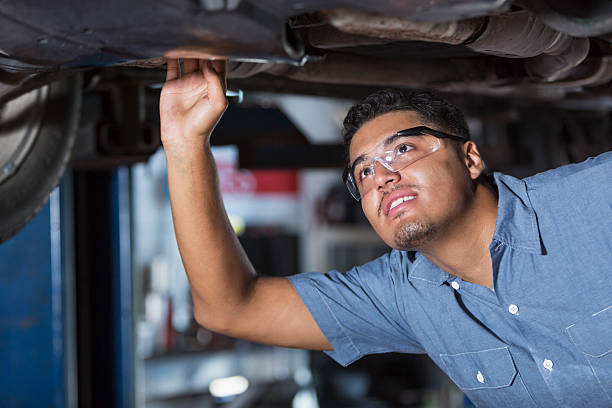 Auto mechanic Hispanic man (20s) working in auto repair shop. car mechanic top view stock pictures, royalty-free photos & images