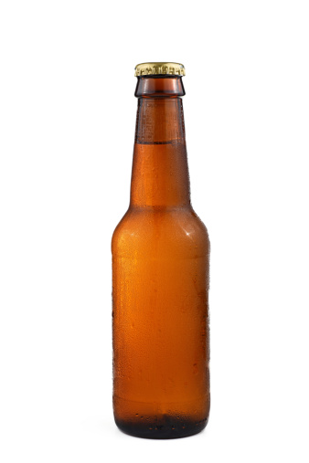 A brown bottle of beer with drops on white background.