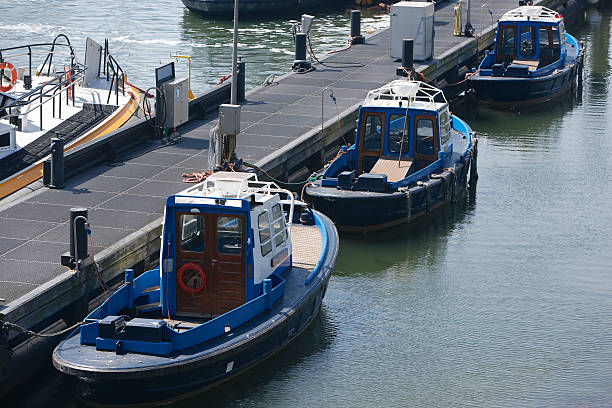 Small Pilot Vessels Row of three smaller and older type of pilot vessel docked at a pier in IJmuiden, The Netherlands. arma-globalphotos stock pictures, royalty-free photos & images