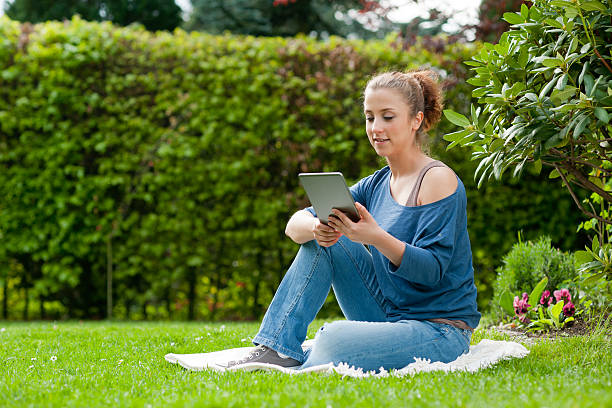 istock Young woman using tablet PC in the garden 493637797