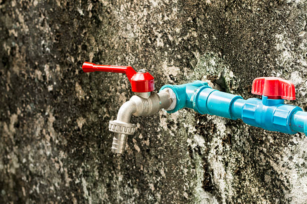 faucet and valve mounted on the wall stock photo