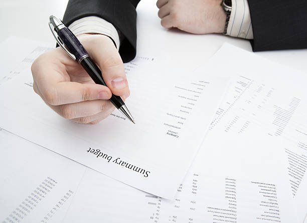 istock businessman holding a pen and counts the budget 493639589