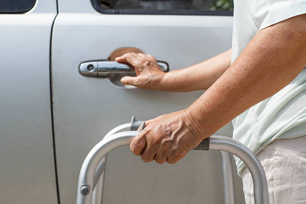 istock senior woman using a walker at car park 493639751