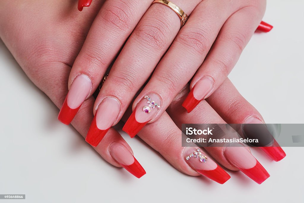 Red french nail art with rhinestones Red french nail art with rhinestones on white background Nail Art Stock Photo