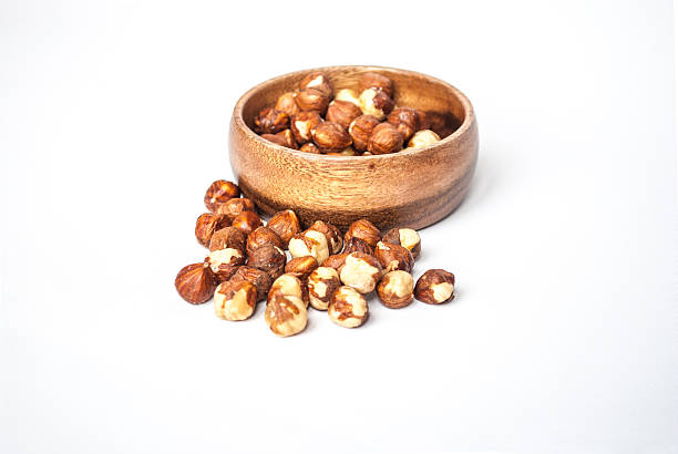 istock Hazelnuts in a Wooden Bowl on White Background 493649402