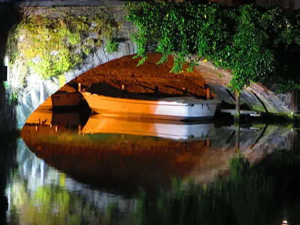 Photo of Reflections of Boat Under Bridge