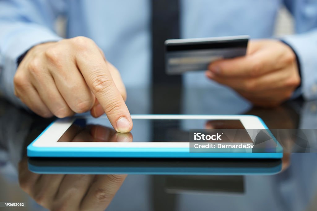 Empresario es comprar mercancías en tableta con tarjeta de crédito - Foto de stock de Préstamo libre de derechos