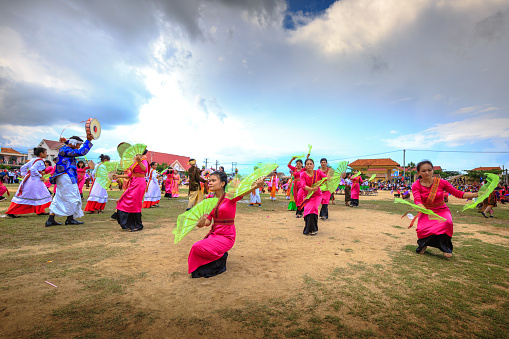 Phan Rang city, Vietnam - October 12, 2015: Dance performance at stadium in Kate festival, group of Vietnamese woman wear colorful tradition clothing dance with fans, Phan Rang city, Ninh Thuan province, Vietnam